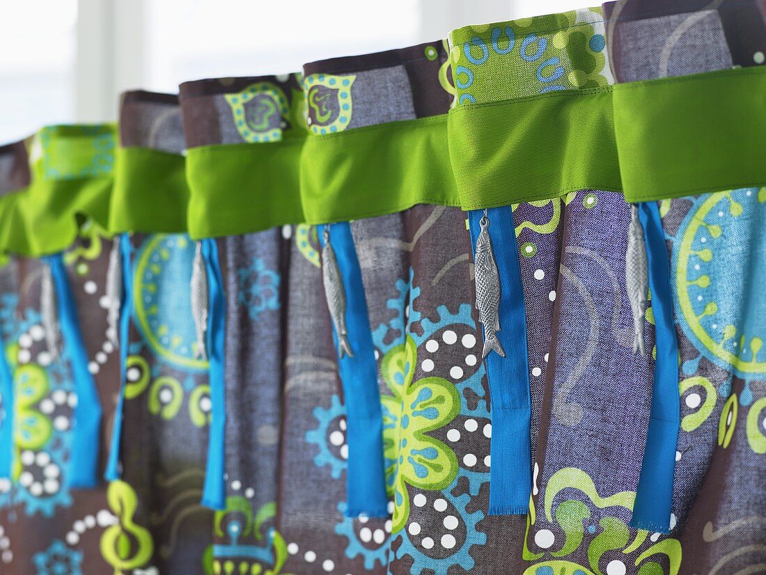 A colourful curtain with a green ribbon