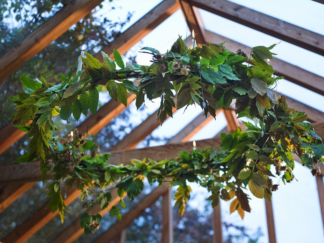 A wreath of leaves hanging from a glass ceiling