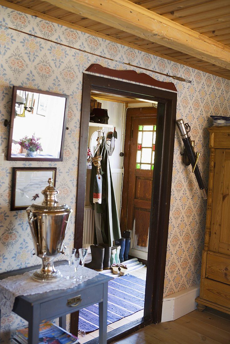 Ländliches Holzhaus - Samovar auf Wandtisch, Türöffung mit Blick auf Haustür