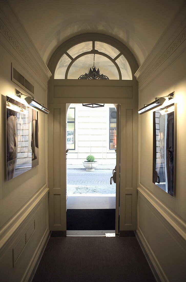 Hallway with an open front door with a fanlight with a view onto a street
