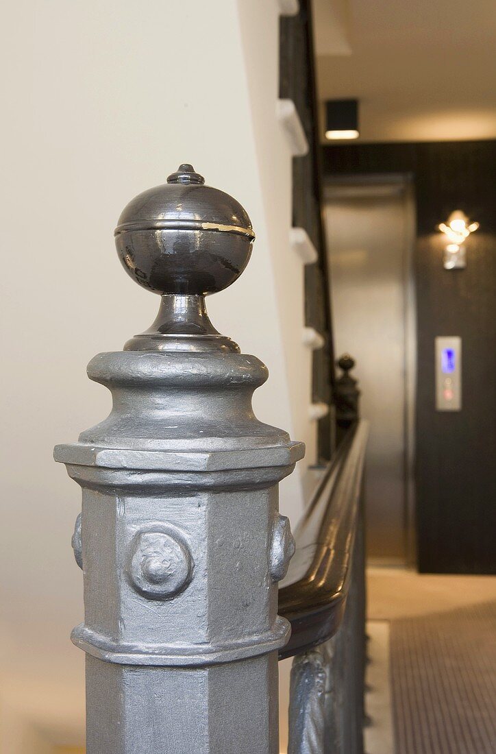 Newel post with round ball on top at the bottom of a stairway
