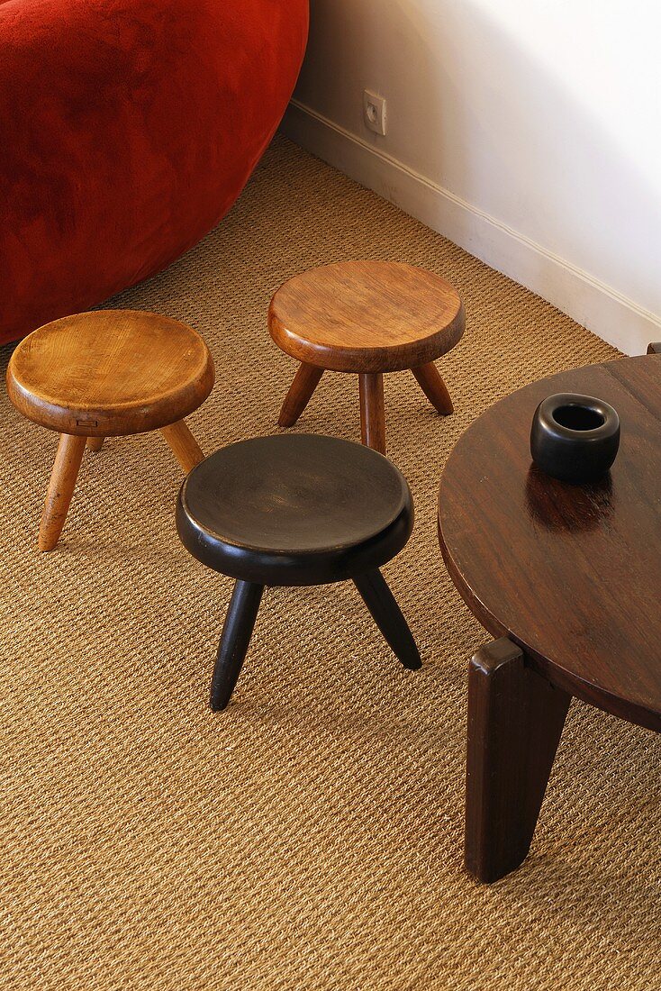Three small wood stools and a side table on sisal flooring