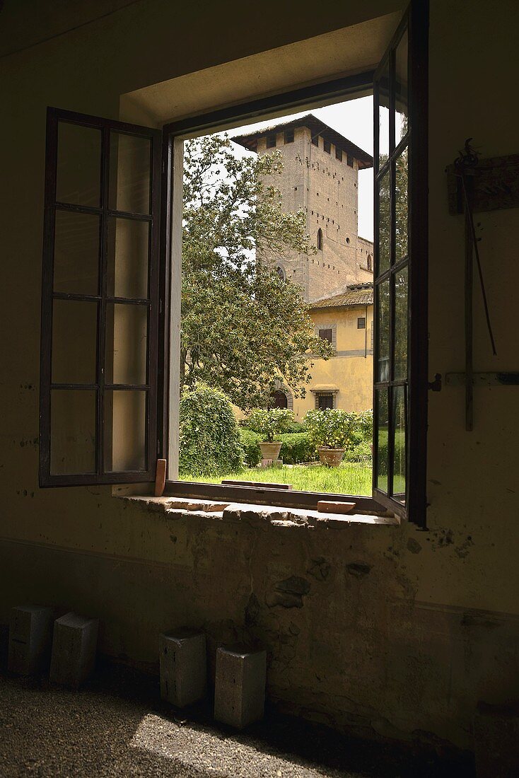 Blick durch Fenster auf italienisches Gehöft mit Turmbau