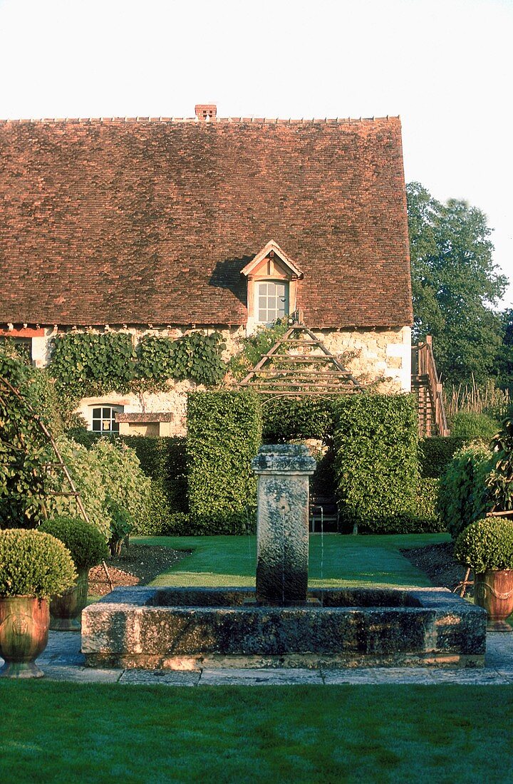 Stone fountain in the well manicured garden of an old country home