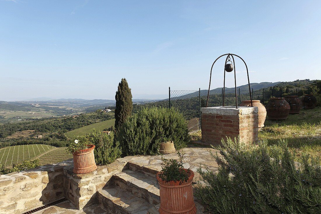 Ziehbrunnen im Mediterraner Garten und Treppenstufen aus Naturstein