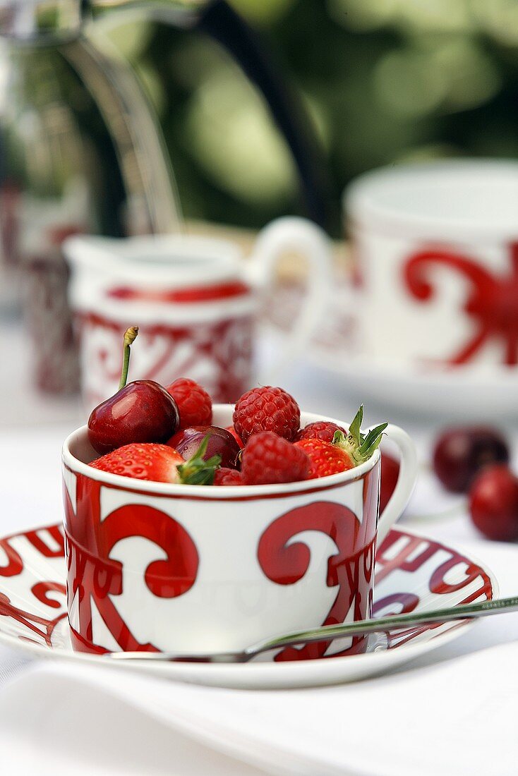 Patterned tea cup with red berries and cherries