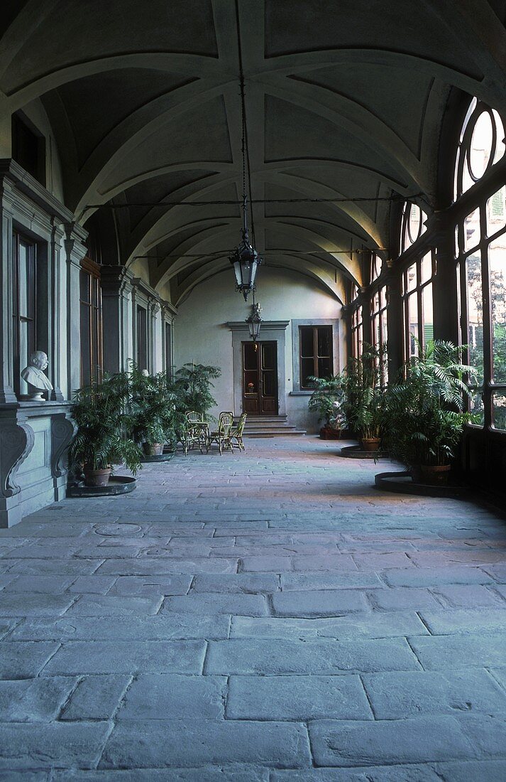 Spacious loggia with a bank of window and stone floor in a villa