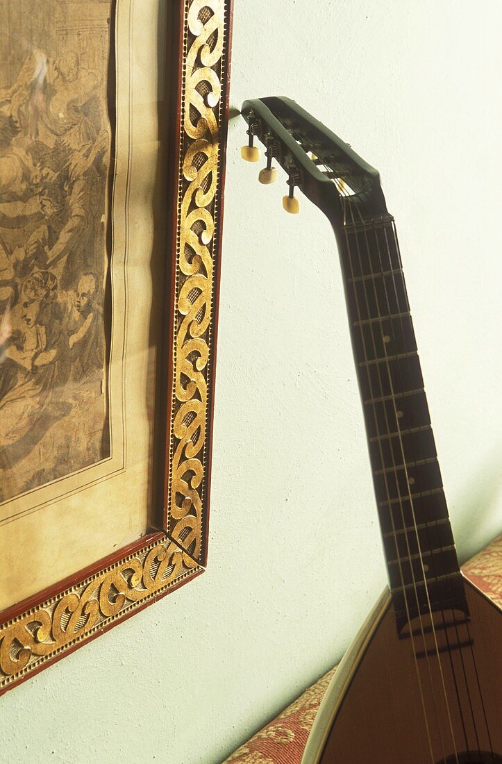 Mandoline an der Wand mit gerahmtem Bild