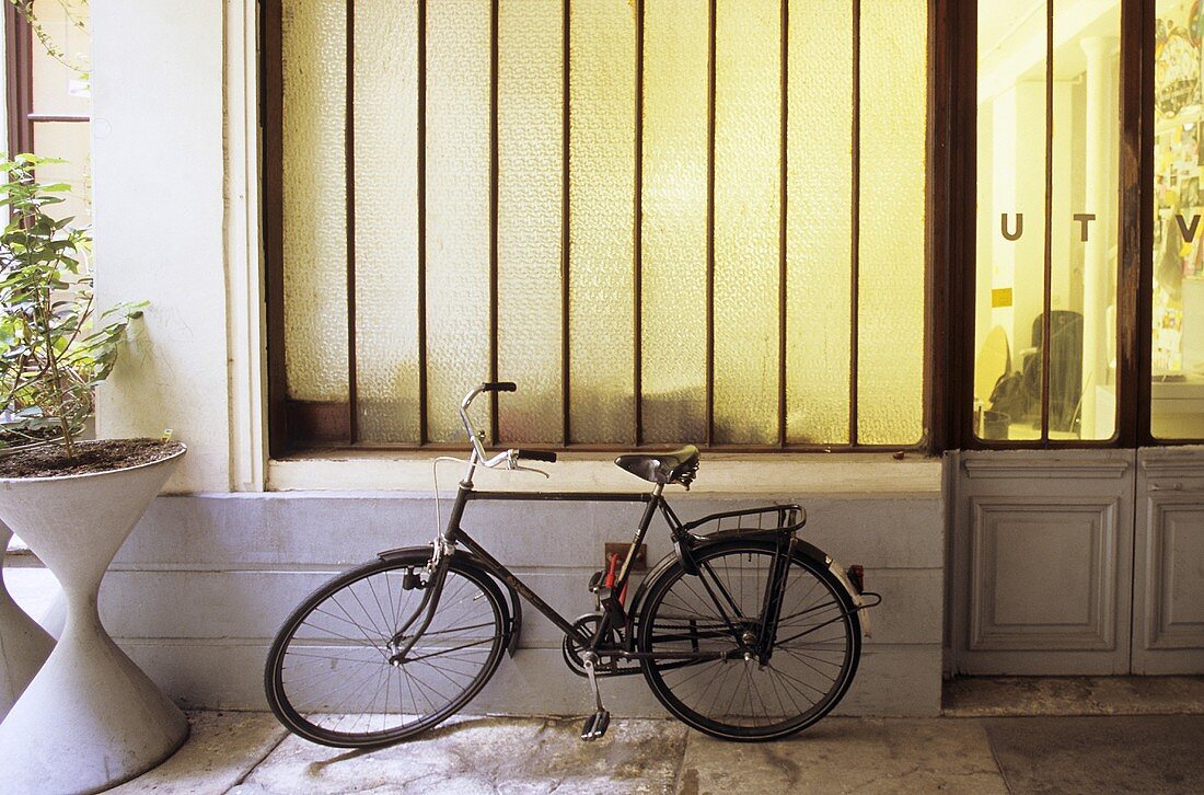 Fahrrad parkt im Hausdurchgang vor blickdichtem Schaufenster