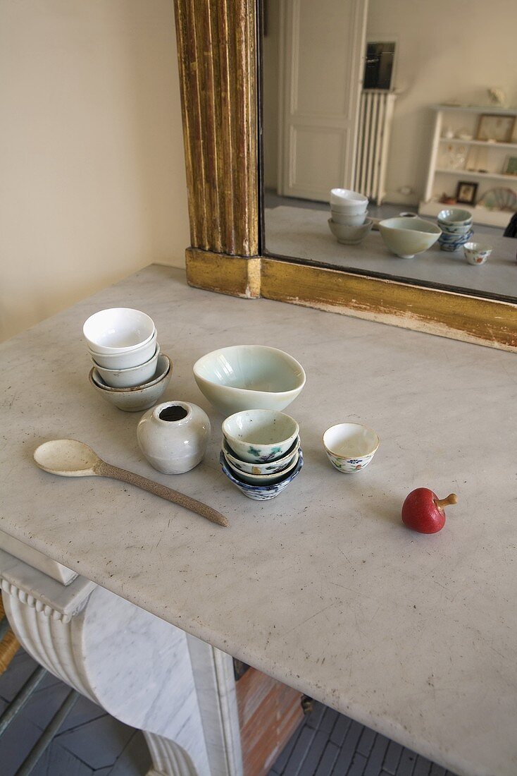 Dishes on a stone countertop in front of a mirror