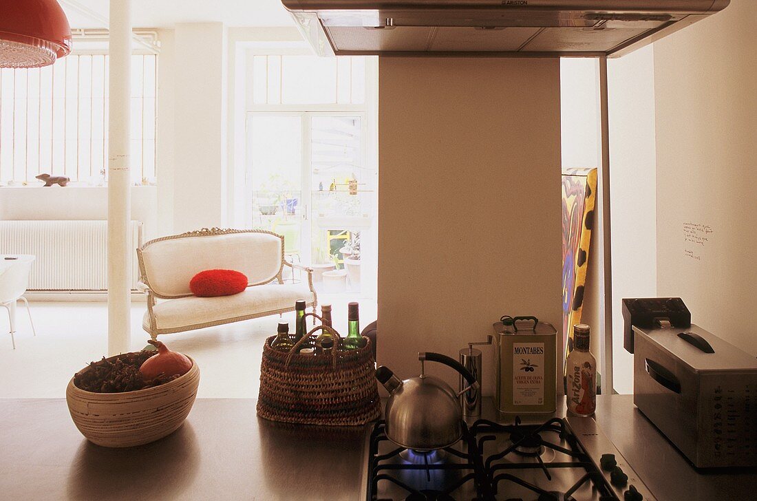 Offene Küche - Küchenblock mit integriertem Gasherd und Blick auf antike gepolsterte Sitzbank im Wohnraum