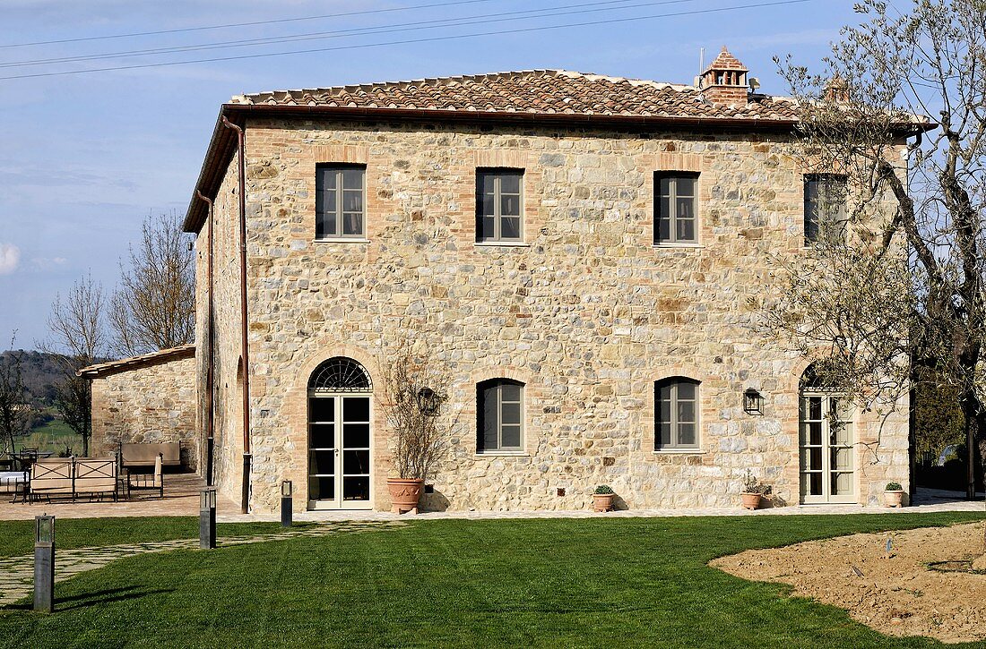 Several storey country home with natural stone facade and a well manicured lawn