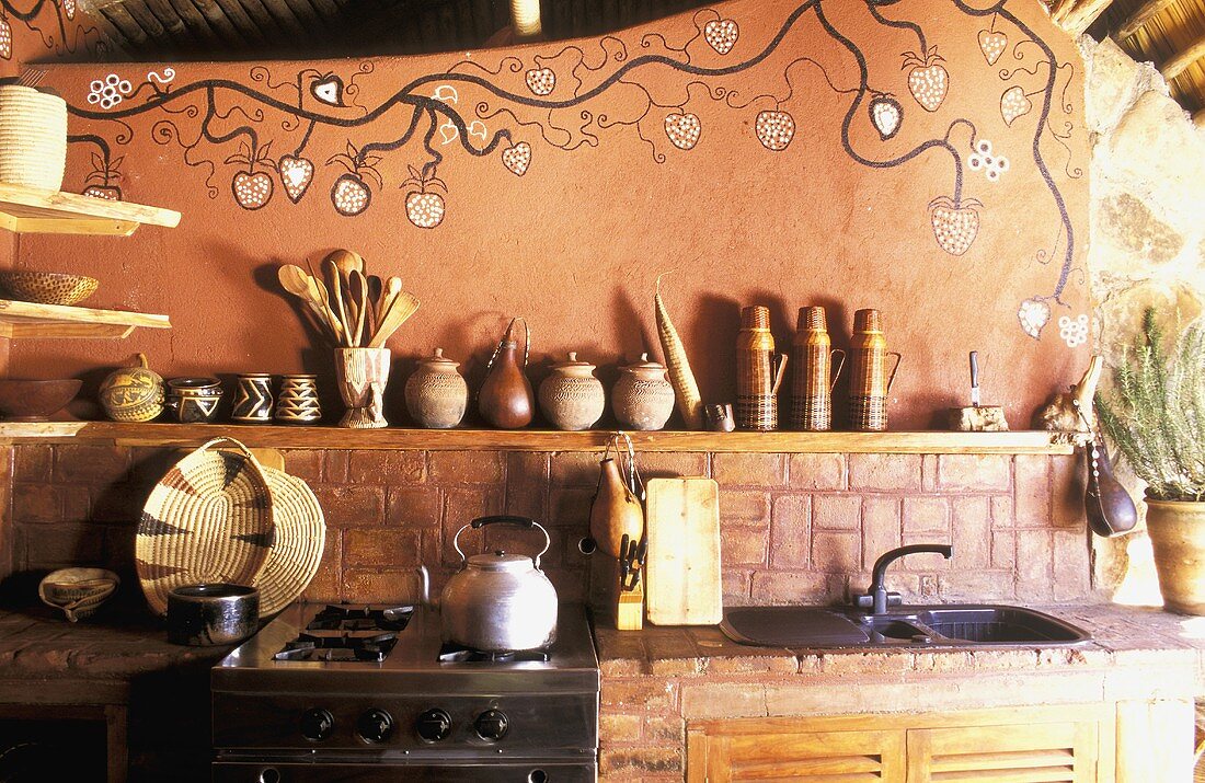 A rustic, African-style kitchen with a painted wall
