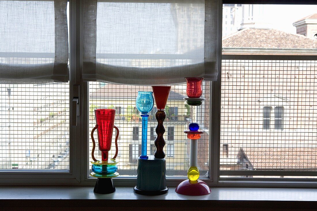Bunte Glaskerzenständer auf der Fensterbank