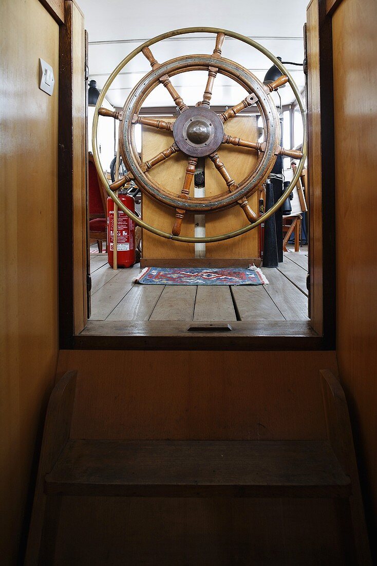Wooden steering wheel in the pilot house of a house boat