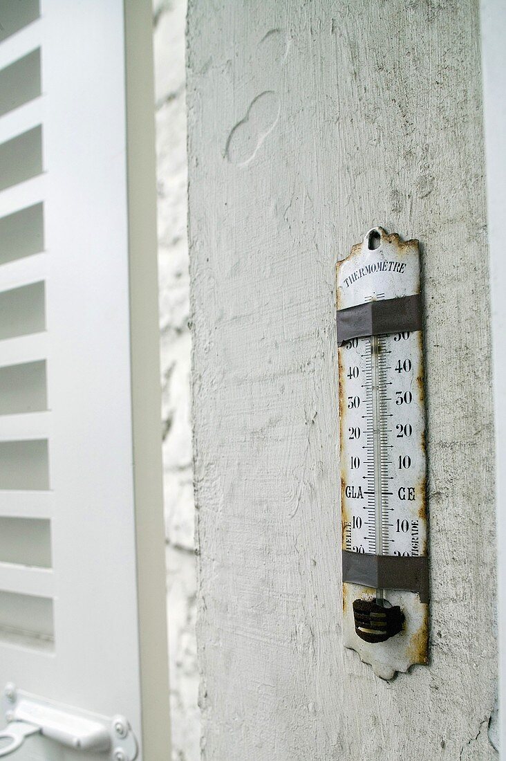 Weathered thermometer on an outside wall