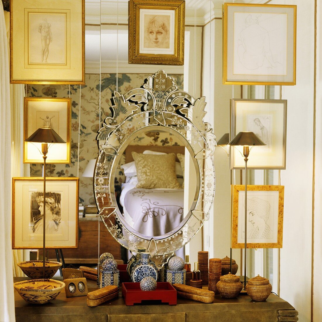 Bildersammlung mit Goldrahmen vor Spiegel und verschiedene Behälter auf Ablage