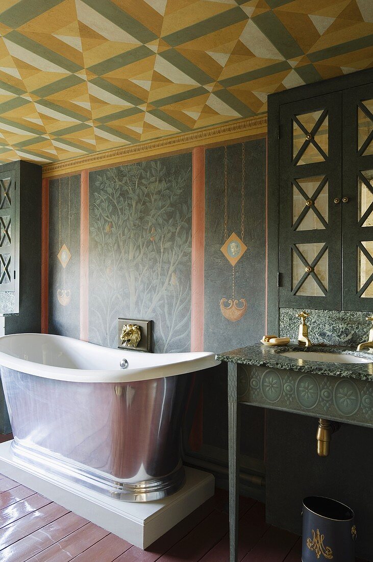 A vintage bathtub on a pedestal with wall taps in a painted room