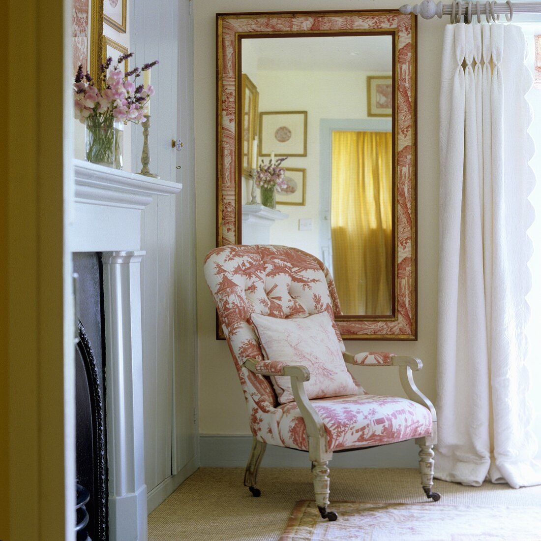 A patterned upholstered armchair in front of a mirror in a bedroom in a country house