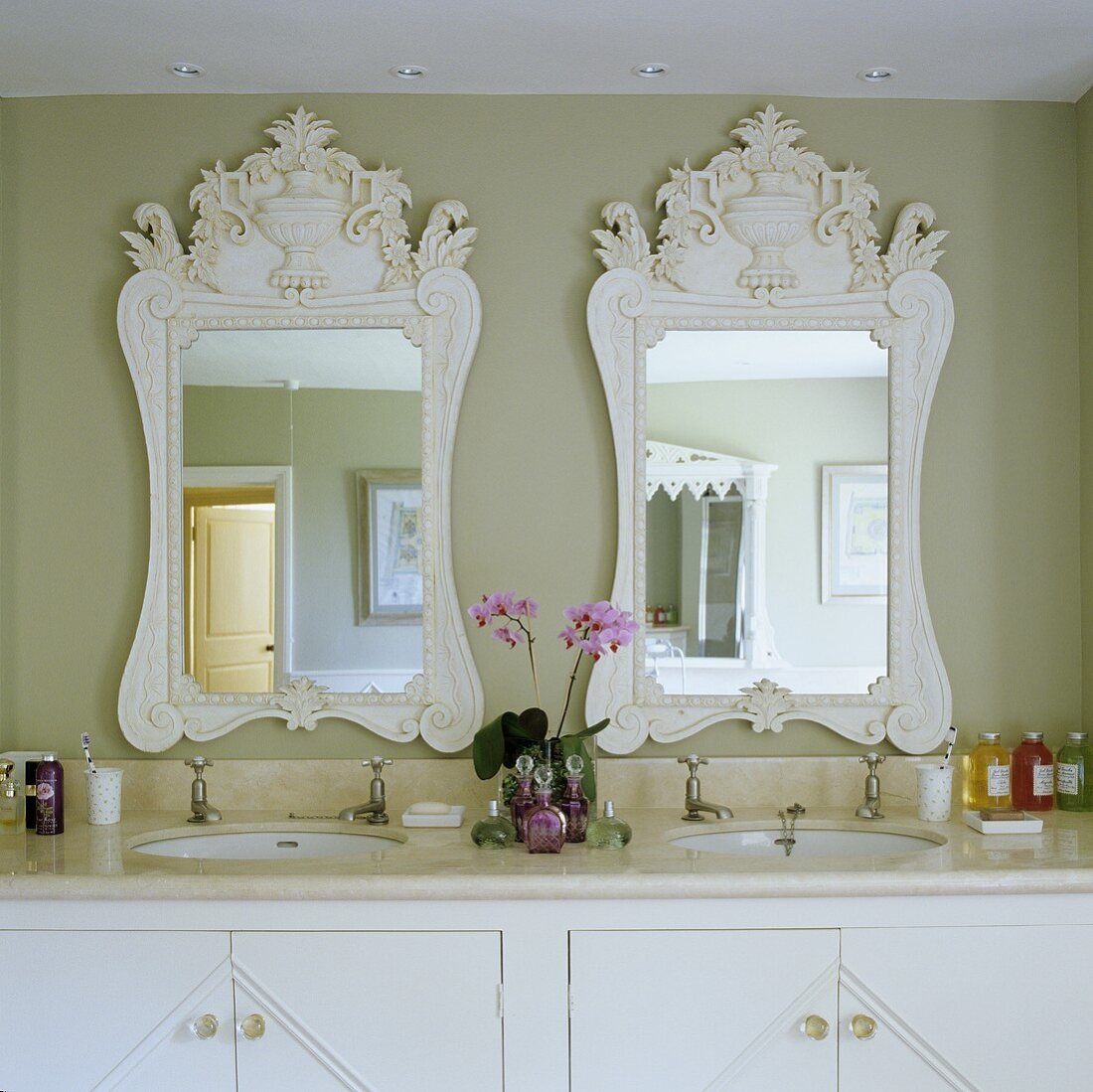 Marmorplatte mit zwei Waschbecken und Spiegel mit weißem Holzrahmen vor graugetönter Wand