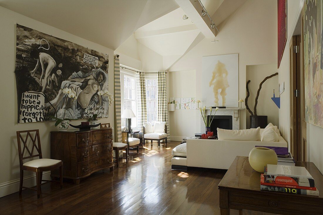 Stilmix im Wohnraum - antike Kommode und weisses modernes Sofa auf Nussbaumparkett