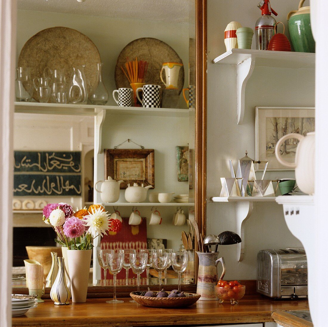 Küchenarbeitsplatte aus Holz mit Gläsern und Geschirr auf weissen Wandkonsolen