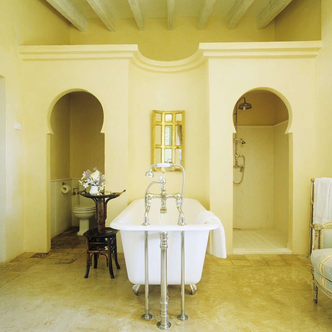 Mediterraner Bad - antike Badewanne mit Standarmatur und Einbau für WC und Dusche mit orientalisch geformter Türöffnung