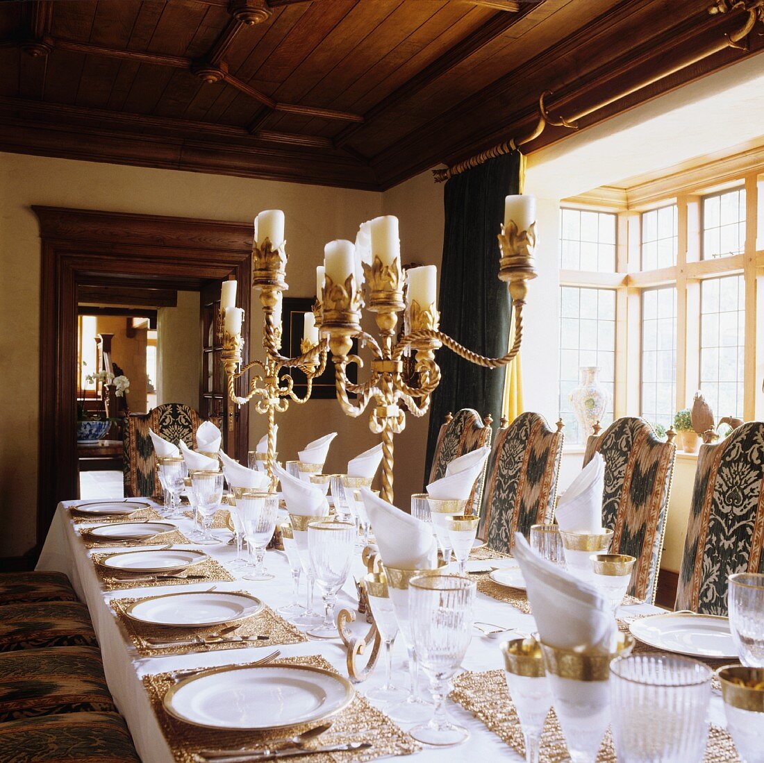 A festively laid table with silver candle sticks in the dining room of a country house