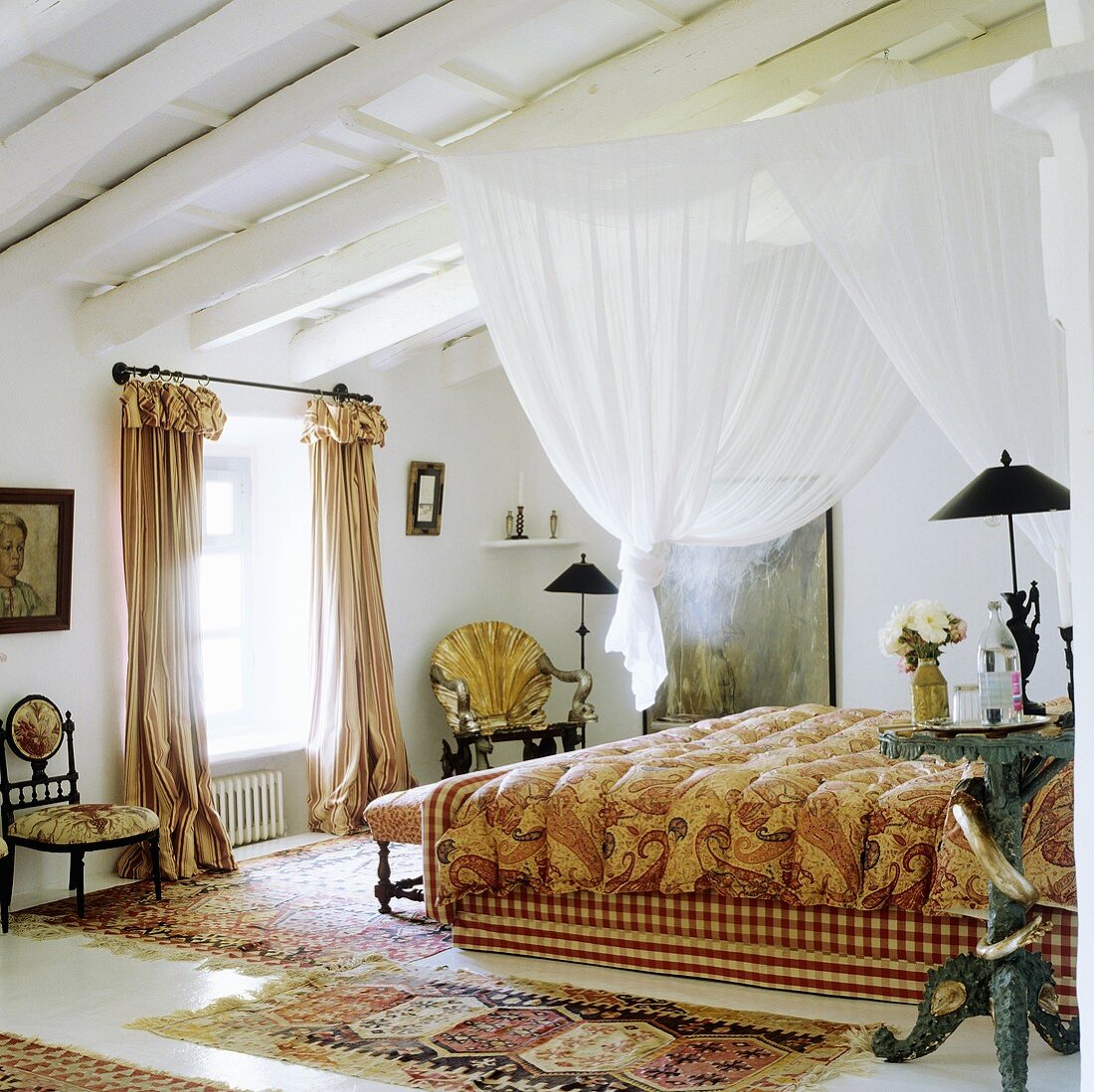 Weisser Stoffhimmel an Holzbalkendecke über Bett und antike Landhausstühle neben Fenster