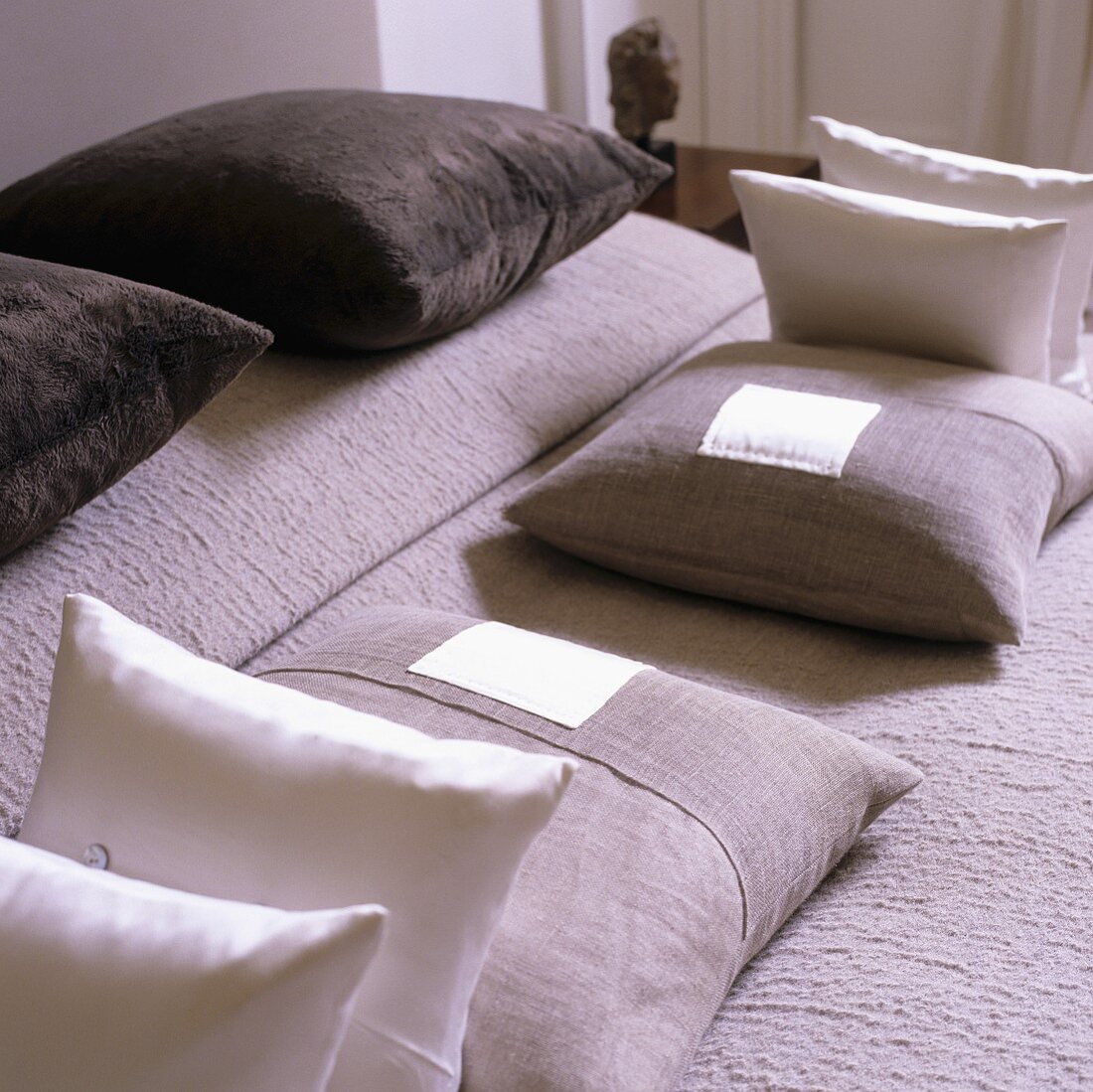 A symmetrical arrangement of cushions on a bed