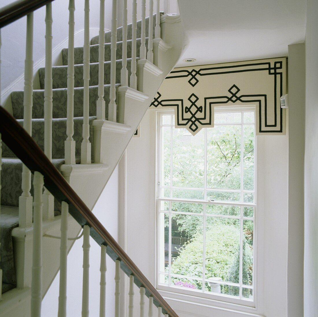 Sprossenfenster mit Schabracke im weißem Treppenhaus