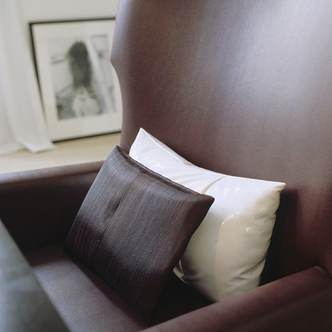 White and brown cushions on a brown leather armchair