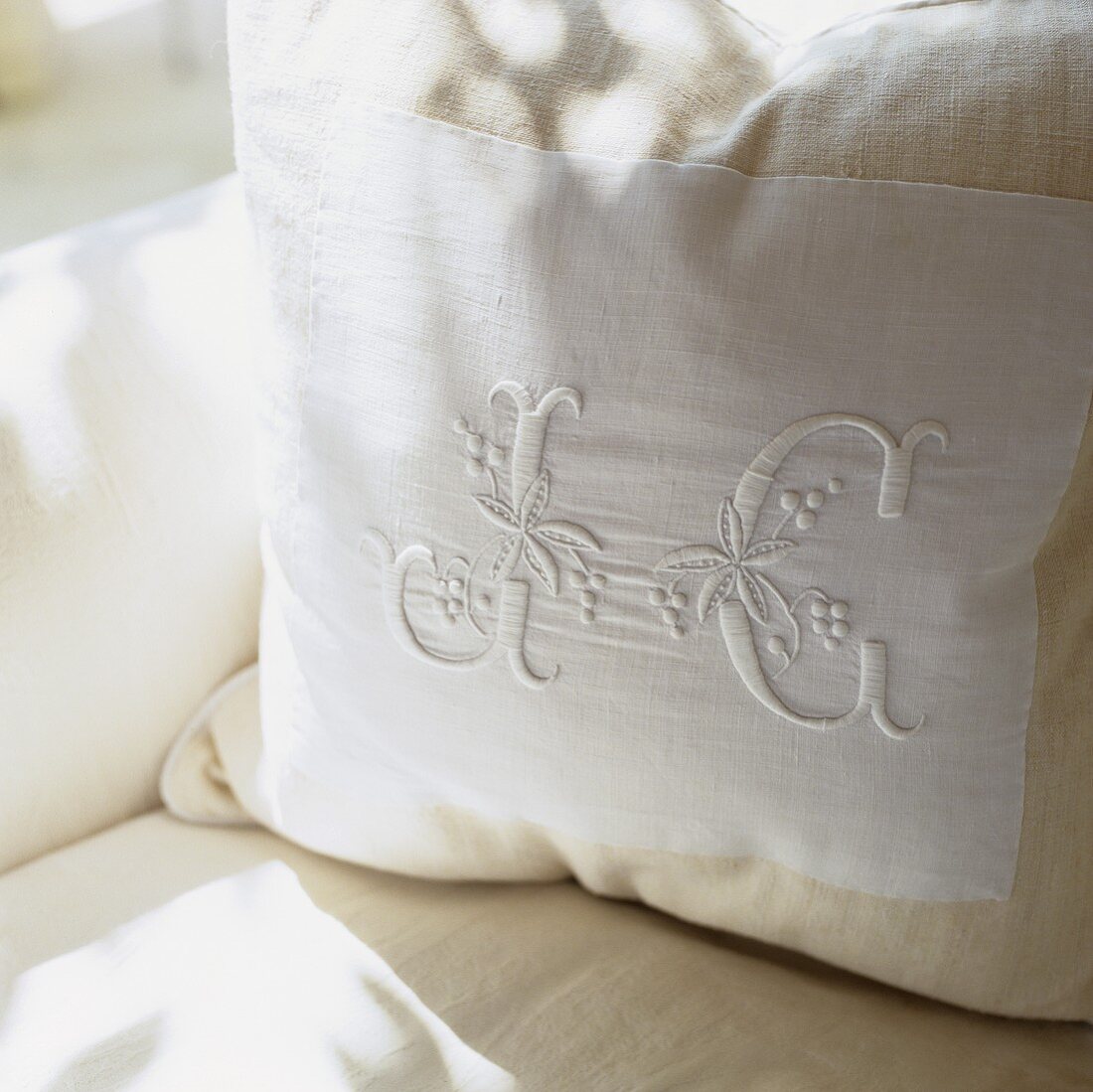 A white cushion embroidered with initials