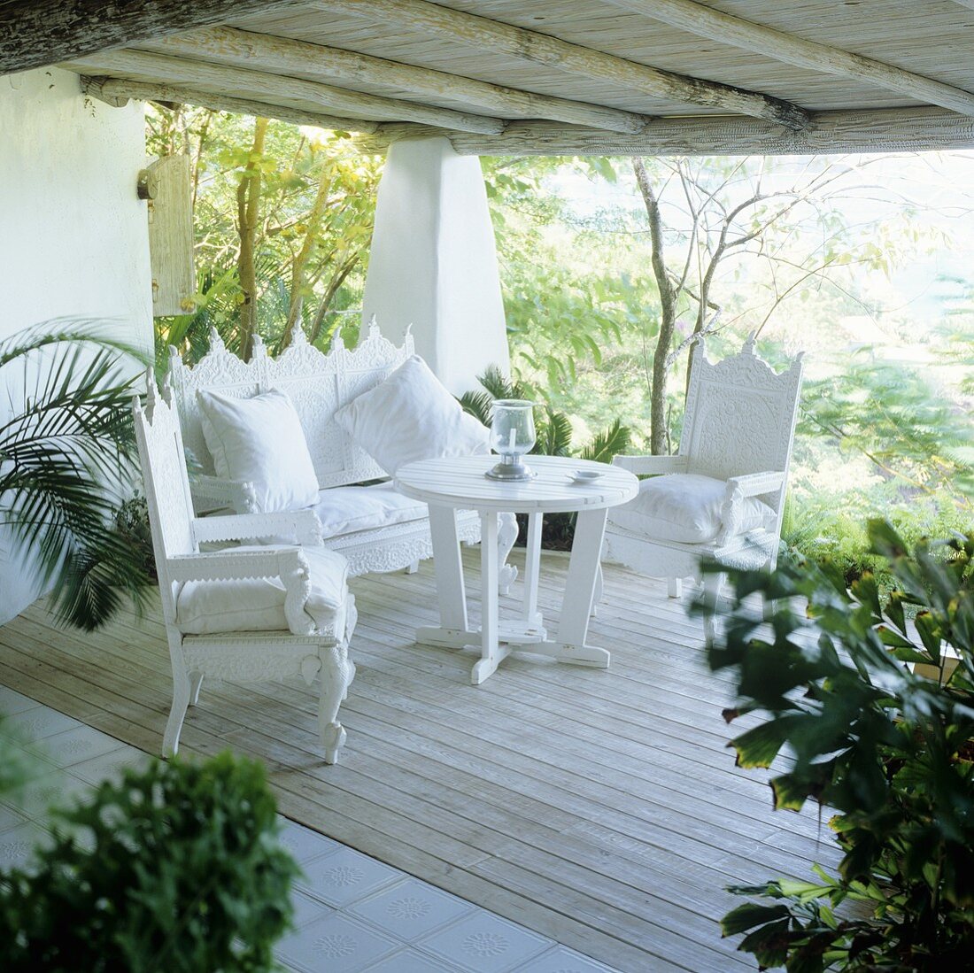 Elegant white, Spanish style terrace furniture on the wooden terrace of a holiday home