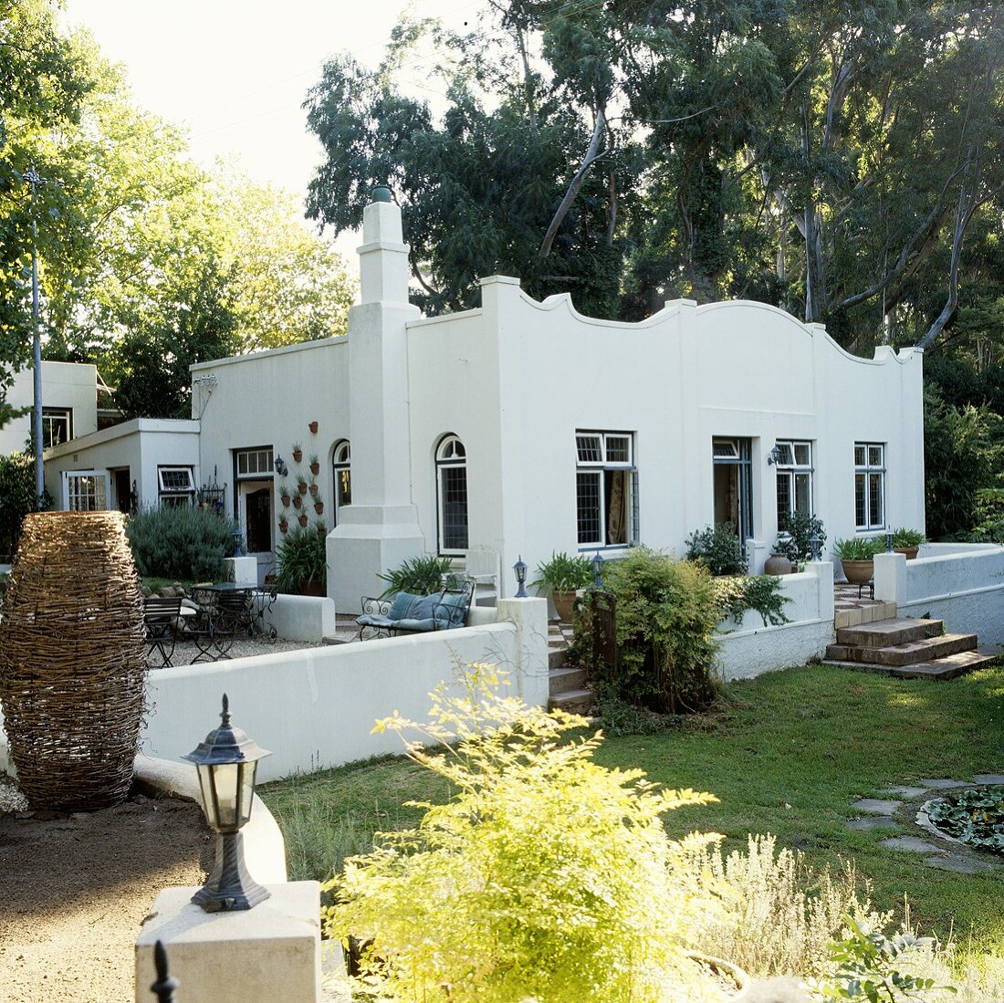 A white house in South Africa with a curved fascia and a terrace