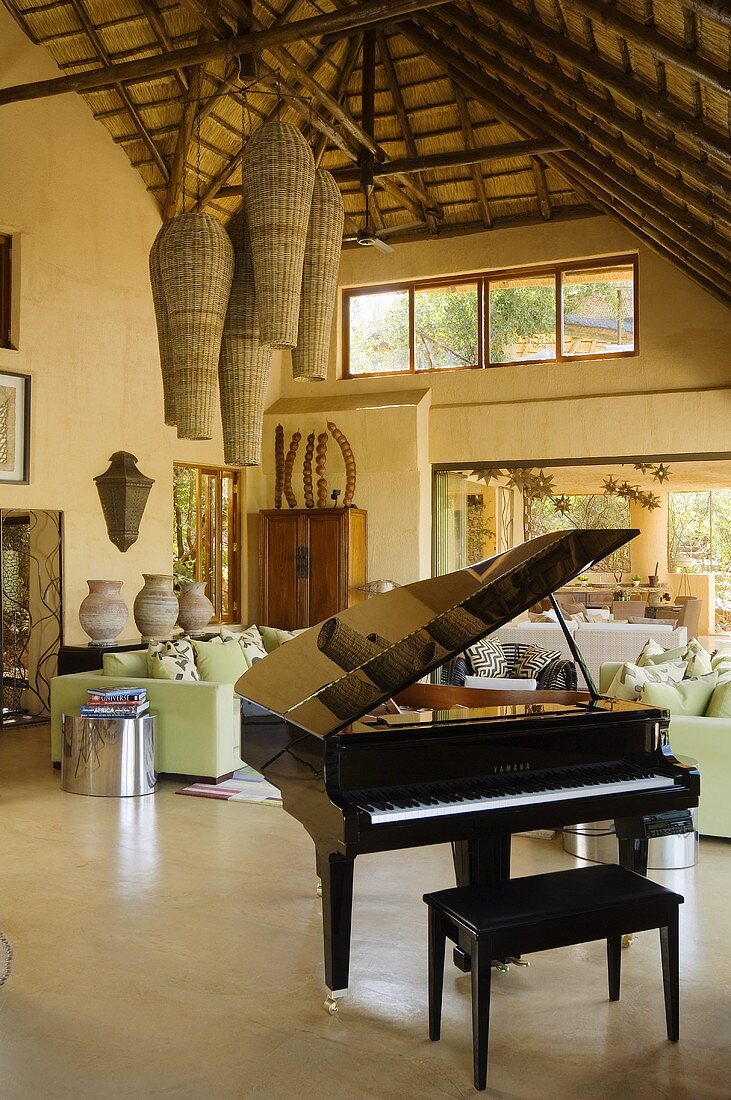 Klavier mit Sitzbank im offenen Wohnraum eines südafrikanischen Landhauses