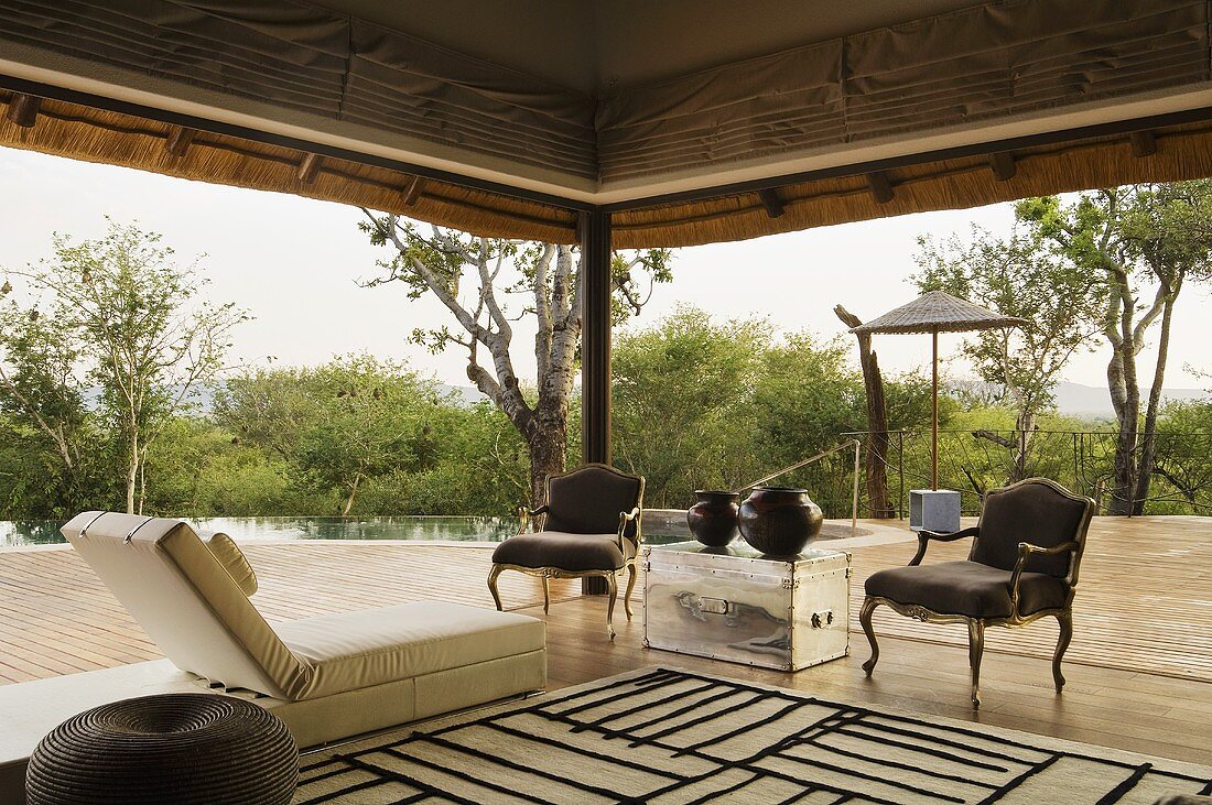 Terrasse eines südafrikanischen Hauses mit Bodenliege und antiken Stühlen