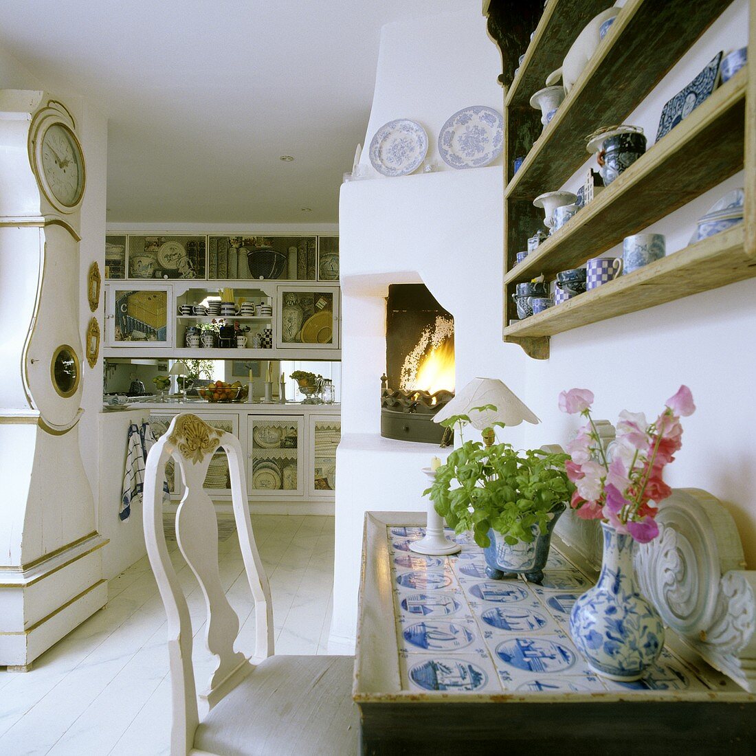 A chair in front of a wall table and an antique grandfather clock in an English kitchen