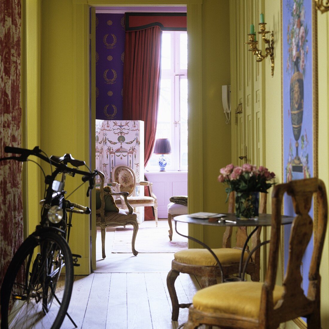 A bicycle parked in a hallway and an open door with a view of the living room