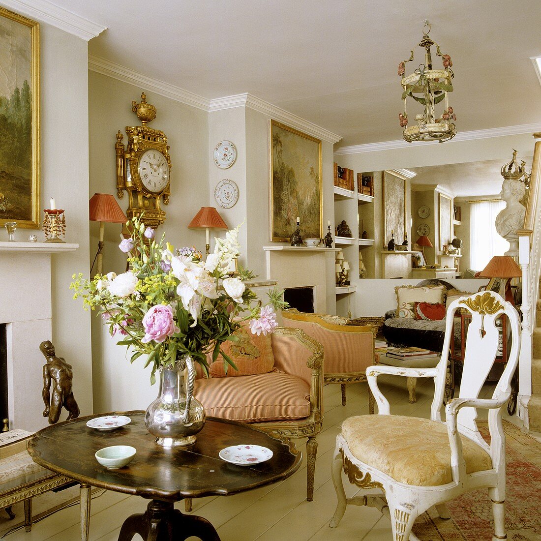 An English living room with Rococo-style armchairs and an antique wooden table