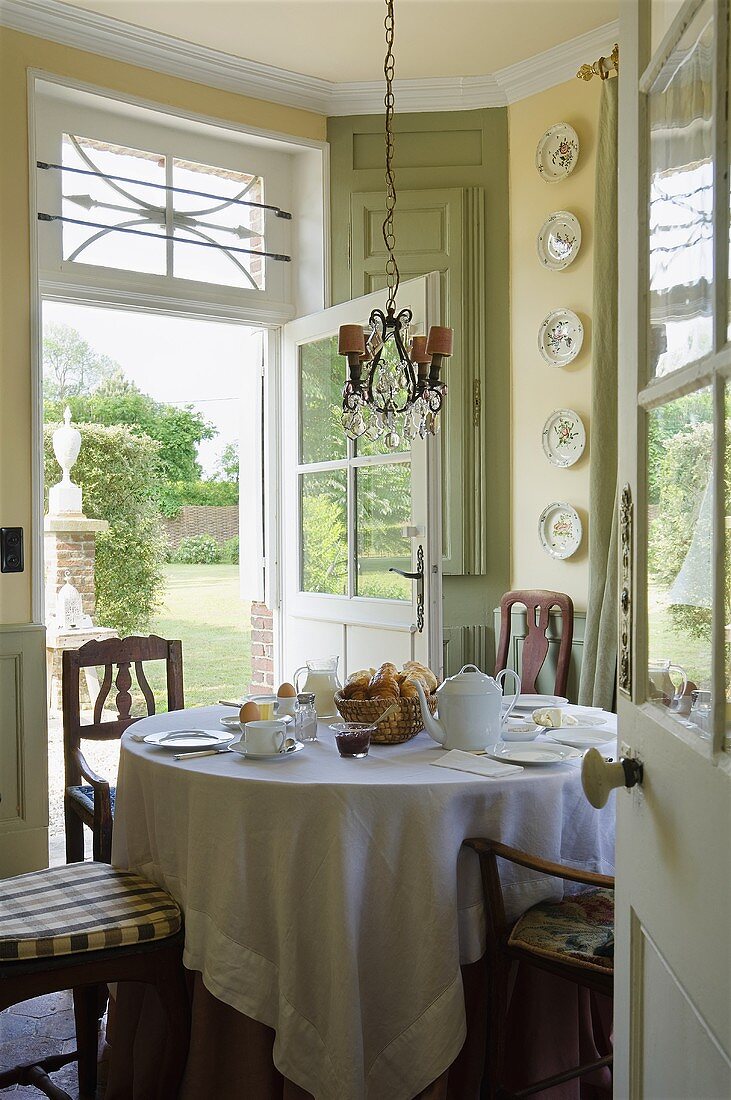 A cosy breakfast in a country house in front of open terrace doors