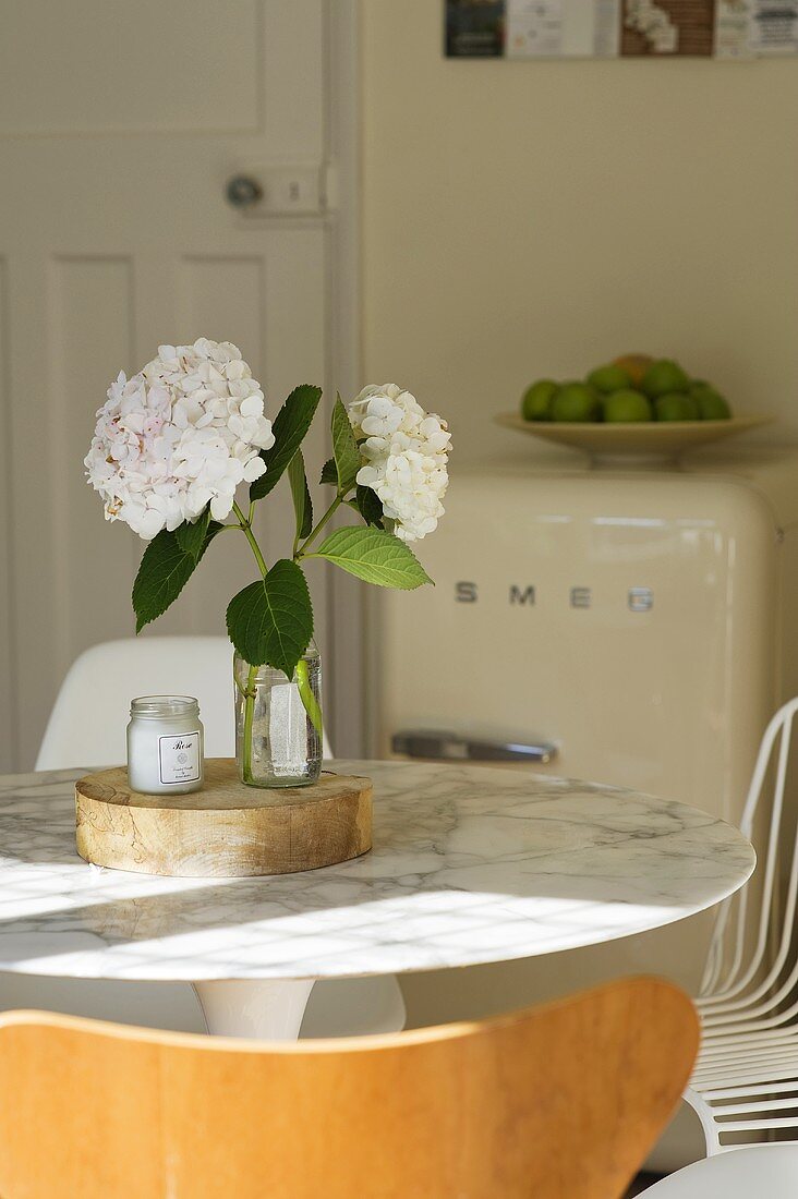 weiße Blumen in Vase auf Esstisch mit Marmorplatte