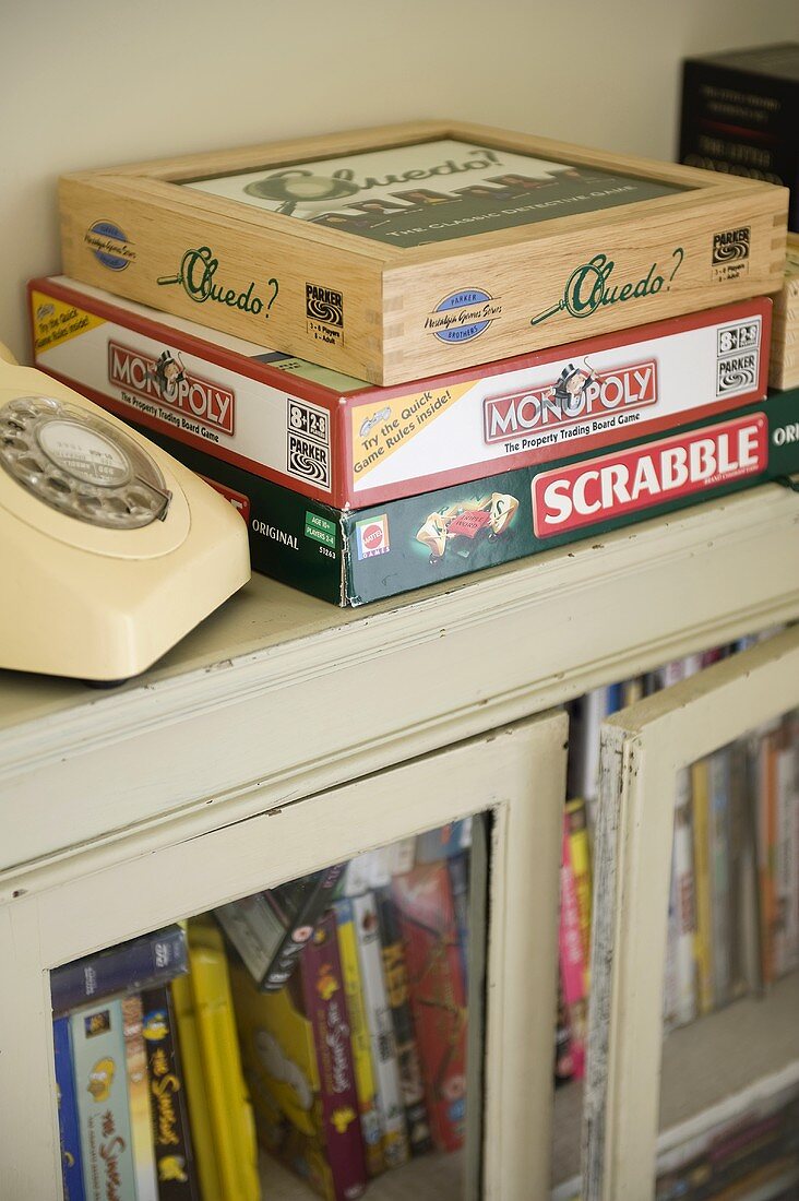 A collection of board games on top of an old cabinet