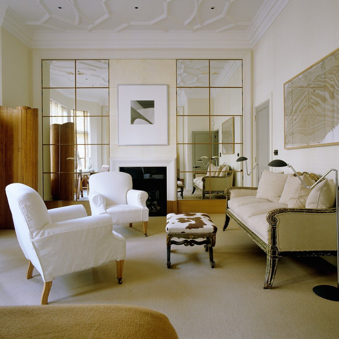 Covered armchairs, an antique three-seater sofa and a side table with a fur cover in an English living room