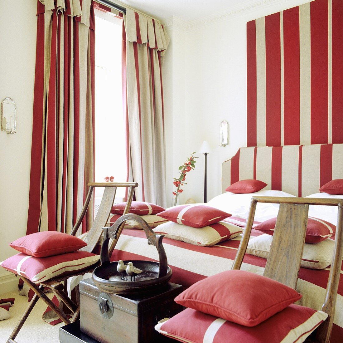Bedroom with red and white stripes on the pillows, bed linen, curtains and wall