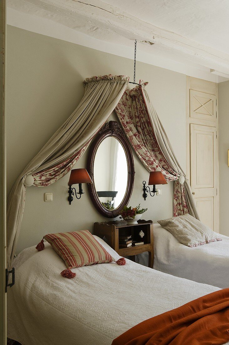 A bedroom in a country house with a canopy over twin beds