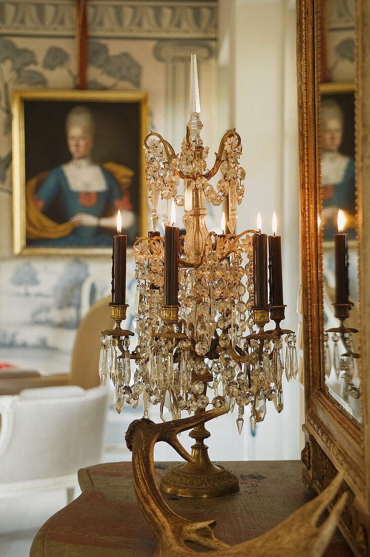 Burning candles in candle holders and a crystal chandelier