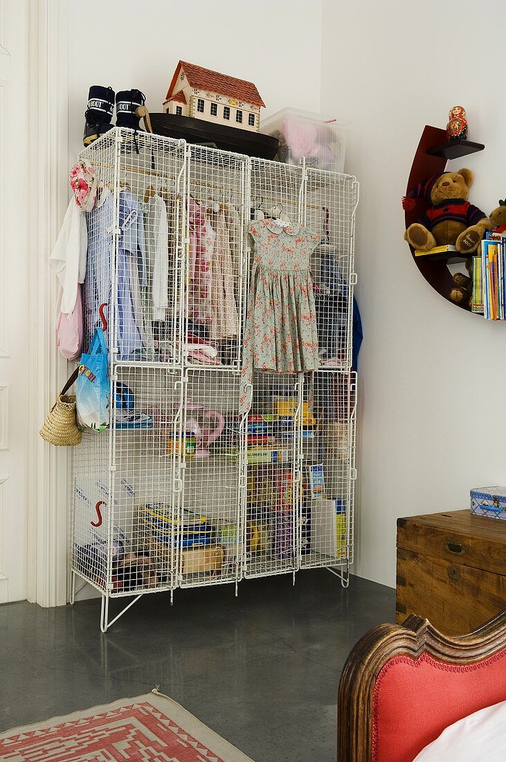 Children's clothes in a cage cupboard