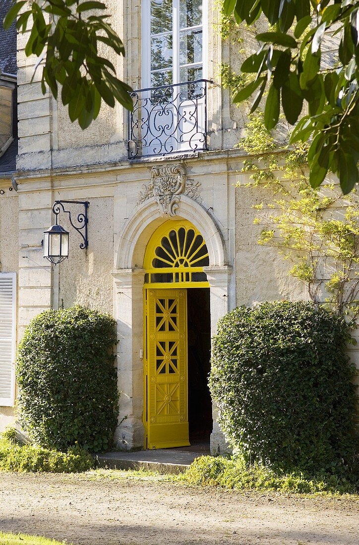 An elegant country house facade - an open yellow front door