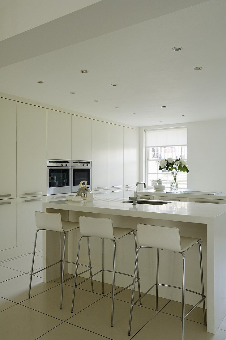 Design in white - a kitchen counter with designer bar stools